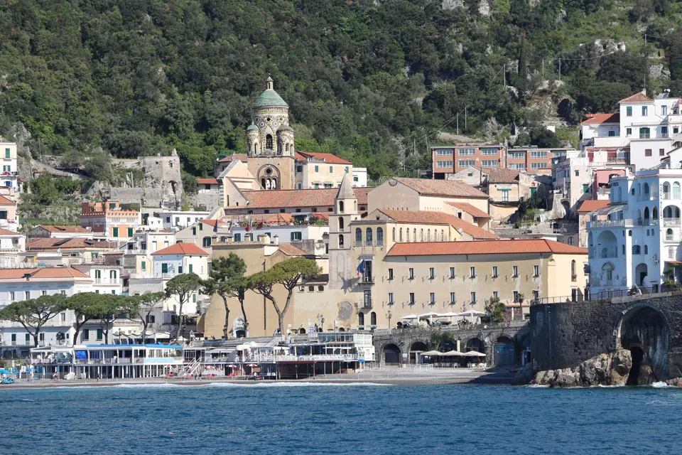 Le case chiare di Amalfi tra le montagne verdi e il mare della Costiera Amalfitana.